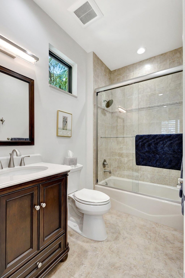 full bathroom with visible vents, toilet, combined bath / shower with glass door, tile patterned flooring, and vanity