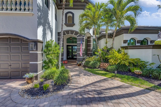 doorway to property featuring a tiled roof, french doors, and stucco siding