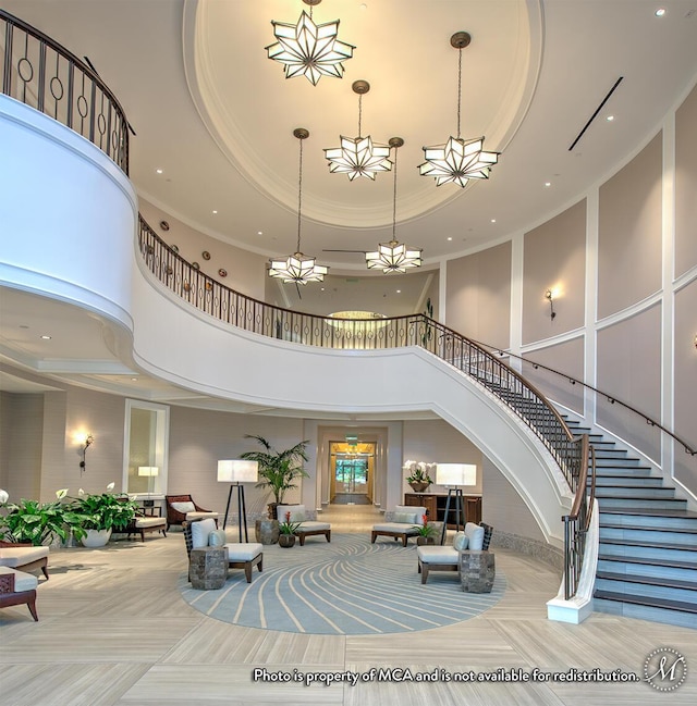 interior space with a tray ceiling, a notable chandelier, recessed lighting, and ornamental molding