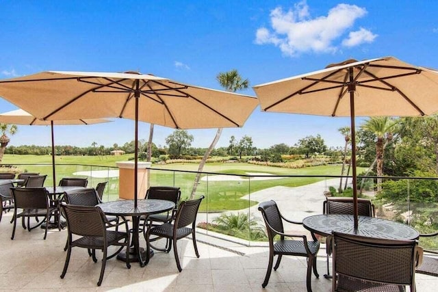 view of patio featuring outdoor dining space and view of golf course