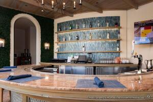 bar featuring arched walkways, beamed ceiling, wooden ceiling, and a chandelier