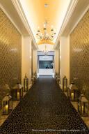 hall featuring a tray ceiling, a chandelier, and ornamental molding