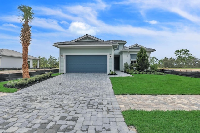 view of front of property featuring decorative driveway, a garage, and a front yard