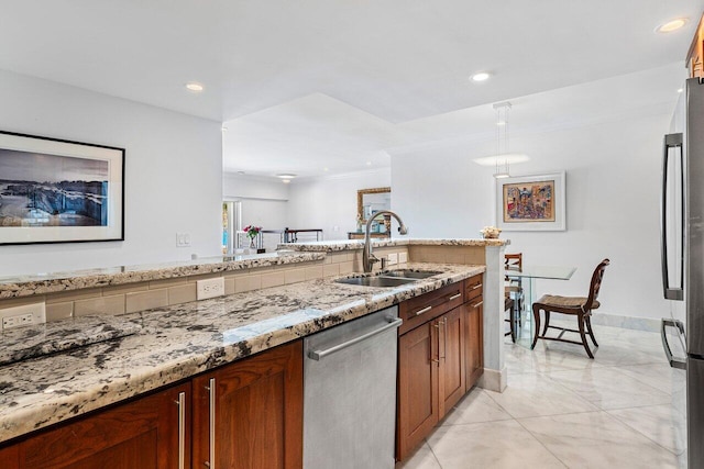 kitchen featuring recessed lighting, light stone countertops, appliances with stainless steel finishes, and a sink