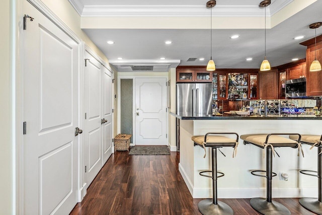 kitchen featuring dark countertops, glass insert cabinets, ornamental molding, dark wood-style floors, and stainless steel appliances