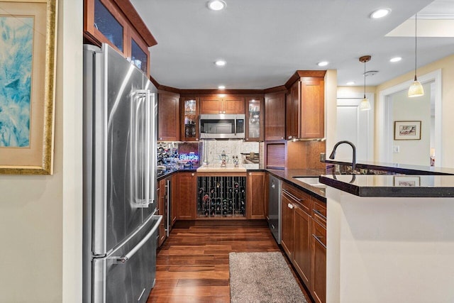 kitchen featuring decorative backsplash, dark wood-type flooring, glass insert cabinets, appliances with stainless steel finishes, and dark countertops