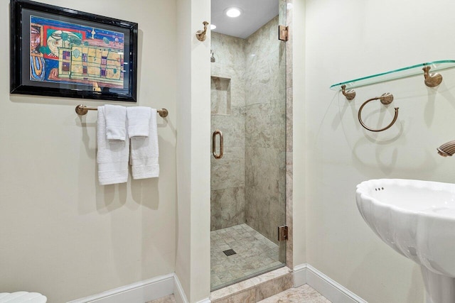 full bath featuring a stall shower and baseboards