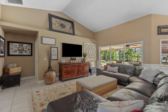 living room with baseboards, light tile patterned floors, a ceiling fan, visible vents, and high vaulted ceiling