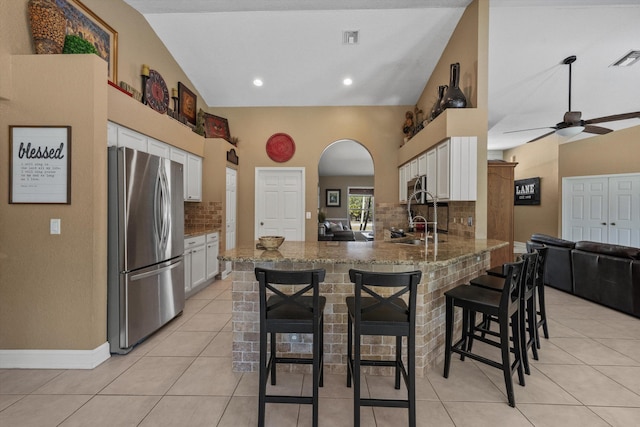 kitchen with appliances with stainless steel finishes, a peninsula, and white cabinetry