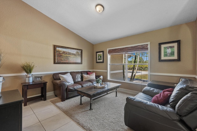 living area with vaulted ceiling, light tile patterned floors, and baseboards