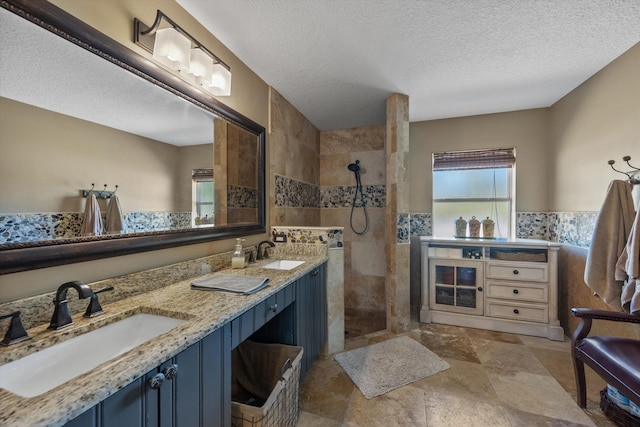 full bathroom featuring a textured ceiling, walk in shower, and a sink