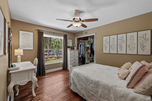 bedroom featuring a ceiling fan, baseboards, wood finished floors, a closet, and a textured ceiling