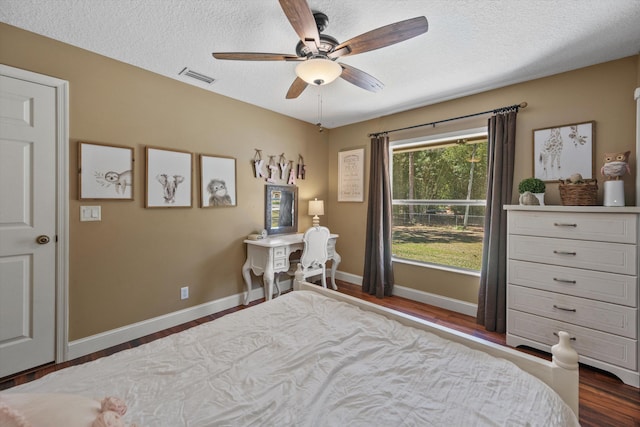 bedroom featuring wood finished floors, baseboards, visible vents, ceiling fan, and a textured ceiling