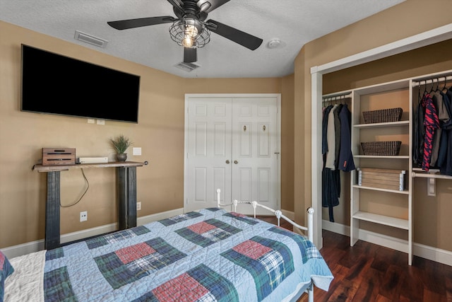 bedroom with a ceiling fan, wood finished floors, visible vents, baseboards, and a textured ceiling