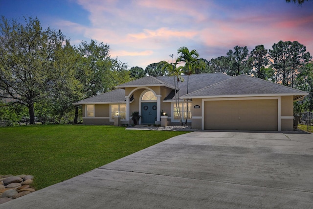 ranch-style house with an attached garage, a shingled roof, stucco siding, a front lawn, and concrete driveway