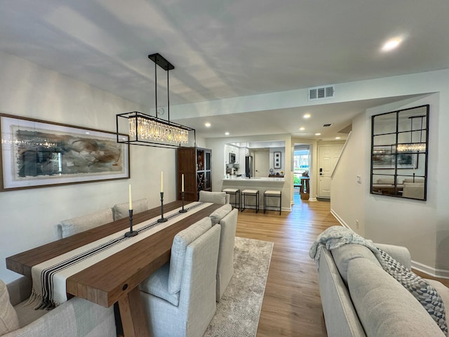 living area with visible vents, recessed lighting, light wood-type flooring, and baseboards