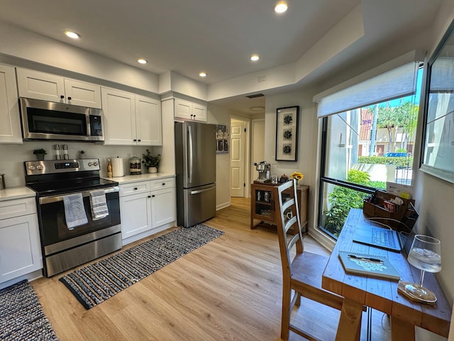 kitchen featuring light countertops, recessed lighting, light wood-style flooring, appliances with stainless steel finishes, and white cabinets