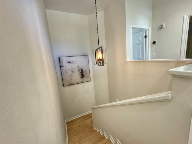 staircase featuring baseboards and wood finished floors