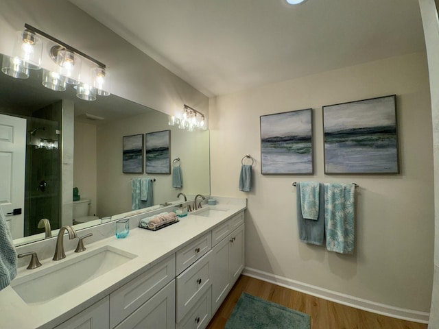 full bathroom featuring a shower stall, toilet, wood finished floors, and a sink