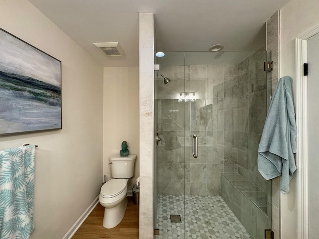 full bathroom featuring a shower stall, toilet, wood finished floors, and baseboards