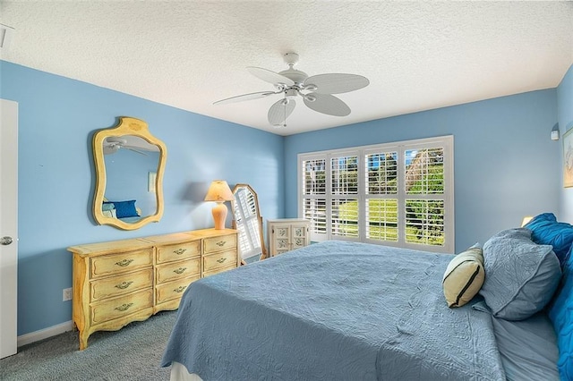 carpeted bedroom with baseboards, a textured ceiling, and ceiling fan