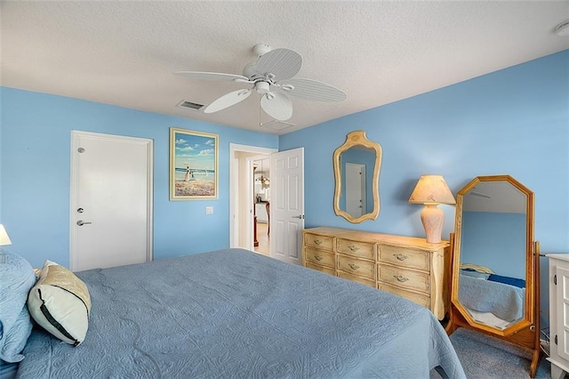 bedroom featuring visible vents, a textured ceiling, and ceiling fan