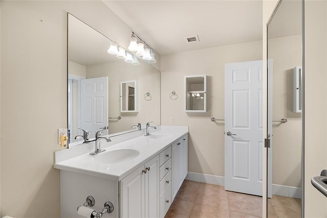 bathroom featuring double vanity, baseboards, visible vents, and a sink