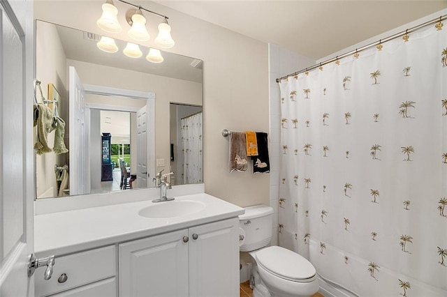 bathroom with vanity, a shower with shower curtain, and toilet