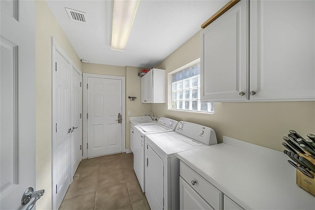 laundry room featuring cabinet space, visible vents, washing machine and dryer, and light tile patterned floors