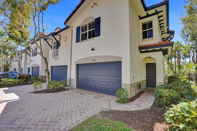 view of front facade featuring a garage, driveway, and stucco siding