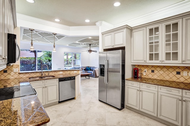 kitchen with a ceiling fan, a sink, open floor plan, stainless steel appliances, and dark stone counters