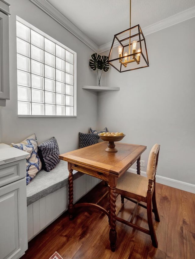 dining room featuring dark wood-style floors, baseboards, an inviting chandelier, and ornamental molding