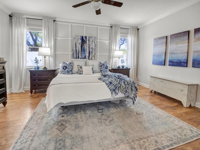 bedroom featuring ceiling fan, multiple windows, wood finished floors, and ornamental molding