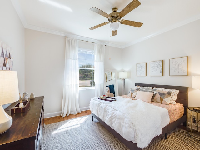 bedroom featuring ceiling fan, wood finished floors, baseboards, and ornamental molding