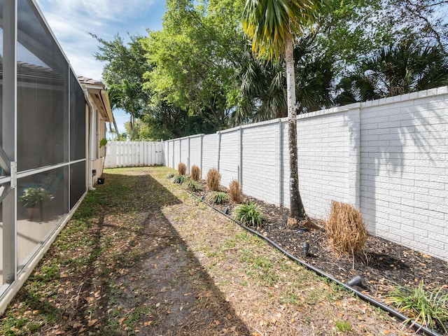 view of yard with a lanai and a fenced backyard