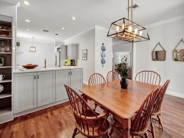 dining area featuring recessed lighting, wood finished floors, visible vents, and ornamental molding