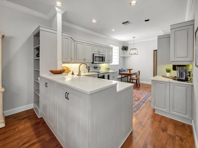 kitchen with wood finished floors, visible vents, a sink, appliances with stainless steel finishes, and crown molding