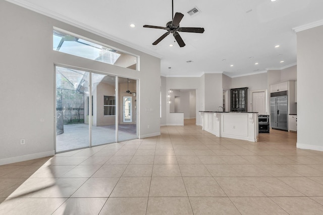 unfurnished living room featuring light tile patterned floors, visible vents, baseboards, and crown molding