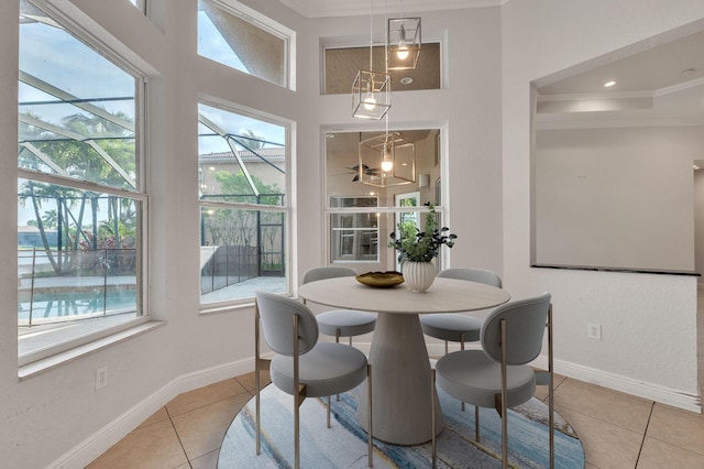 dining area with baseboards, ornamental molding, and tile patterned flooring