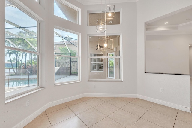 unfurnished room with tile patterned floors, baseboards, and ornamental molding