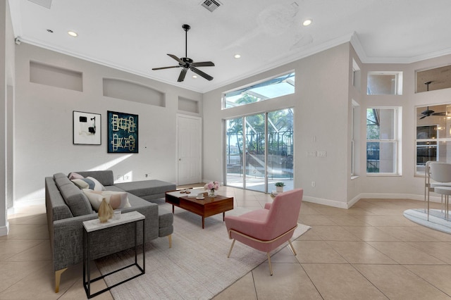 living area with light tile patterned floors, a ceiling fan, baseboards, visible vents, and ornamental molding