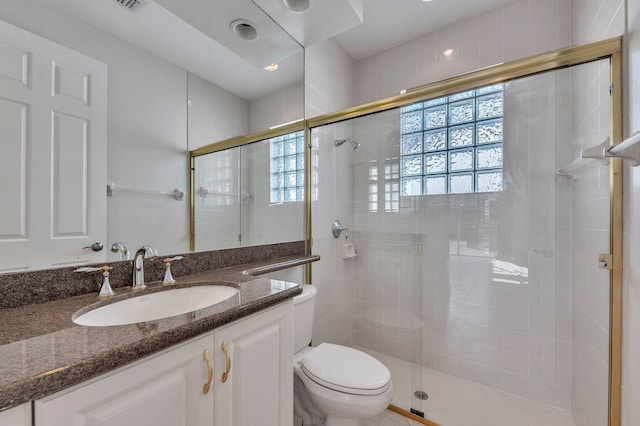 full bathroom featuring vanity, a shower stall, and toilet