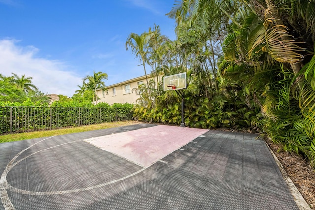 view of basketball court featuring basketball court and fence