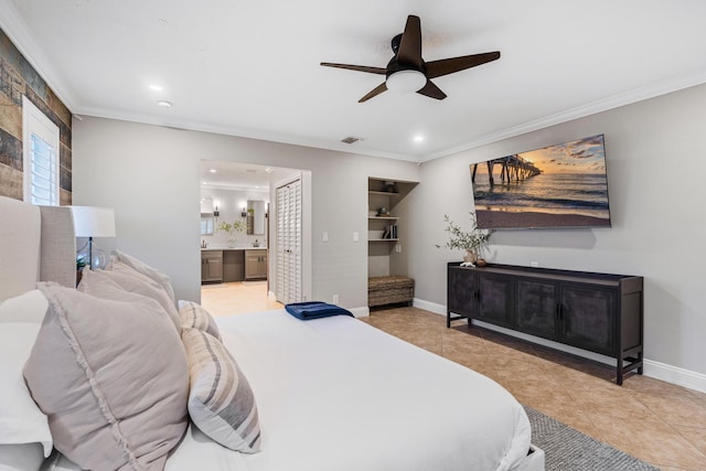 bedroom featuring light tile patterned floors, baseboards, ornamental molding, and ensuite bathroom