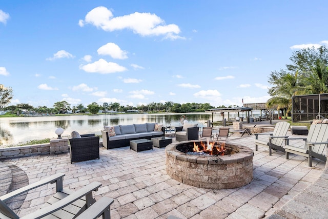 view of patio / terrace featuring a water view and an outdoor living space with a fire pit