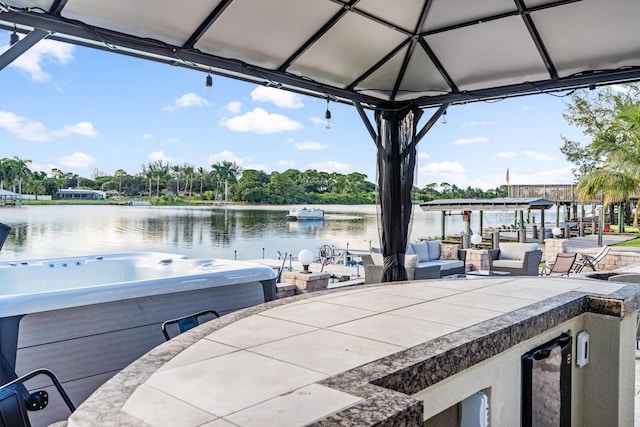 view of dock featuring a gazebo, a water view, and a hot tub