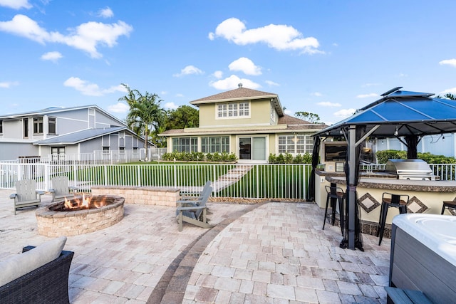 view of patio featuring area for grilling, fence, outdoor dry bar, and an outdoor fire pit