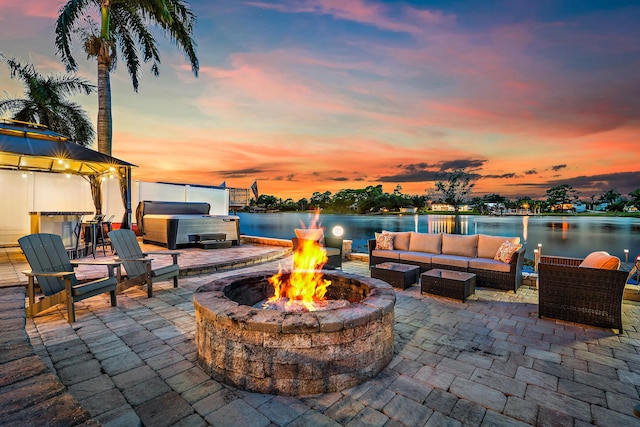 view of patio featuring an outdoor living space with a fire pit, a gazebo, a water view, and a hot tub