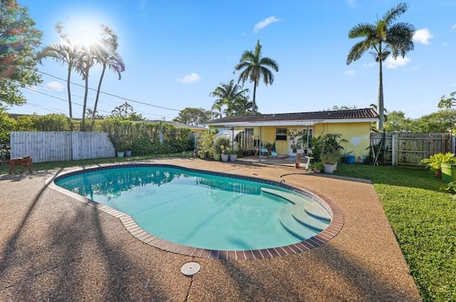 view of swimming pool featuring a patio area, a yard, a fenced in pool, and a fenced backyard