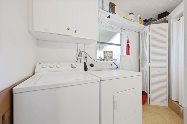 clothes washing area with light tile patterned floors, cabinet space, and washer and clothes dryer